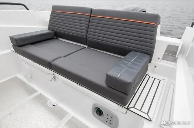 Sleek grey boat seating with orange accents, featuring a cushioned backrest and side armrest, beside a minimalist side table.